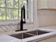 Kitchen sink featuring dark faucet, white countertops, and herringbone tile at 604 Ponderosa Dr, St Cloud, FL 34769