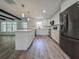 Modern kitchen with white cabinets, stainless steel appliances, and a center island at 604 Ponderosa Dr, St Cloud, FL 34769