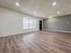 Bright living room featuring wood-look flooring, a large window, and neutral paint colors at 604 Ponderosa Dr, St Cloud, FL 34769