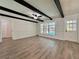 Bright living room featuring wood floors, ceiling fan and beams, and large window overlooking the pool at 604 Ponderosa Dr, St Cloud, FL 34769