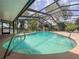 Relaxing screened-in pool area offers clear blue water, lush landscaping, and plenty of space for outdoor entertaining at 604 Ponderosa Dr, St Cloud, FL 34769