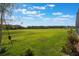 Lush green backyard featuring a wide open space and clear blue skies at 637 Neptune Dr, Groveland, FL 34736