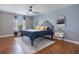 Bright bedroom with hardwood floors, ceiling fan, large window with natural light, and stylish decor at 637 Neptune Dr, Groveland, FL 34736