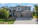 Charming two-story home with a well-maintained lawn, three-car garage, and beautiful landscaping at 637 Neptune Dr, Groveland, FL 34736