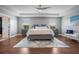 This main bedroom features a tray ceiling, ceiling fan, modern decor, and hardwood floors at 637 Neptune Dr, Groveland, FL 34736