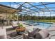 Relaxing screened-in pool area with bar, outdoor lounge chairs, and lush green landscape at 637 Neptune Dr, Groveland, FL 34736