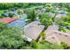 Aerial view of a home featuring a neutral roof with screened in back porch and lush landscaping in a planned community at 645 Highlands Hammock Dr, Kissimmee, FL 34759