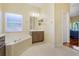 Bathroom with large tub, neutral finishes, and natural light creating a relaxing spa-like atmosphere at 645 Highlands Hammock Dr, Kissimmee, FL 34759