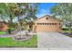Charming single-Gathering home featuring a two-car garage, a brick paver driveway, and meticulously maintained landscaping at 645 Highlands Hammock Dr, Kissimmee, FL 34759