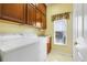 Laundry room featuring a window, a washer and dryer, and upper cabinets at 645 Highlands Hammock Dr, Kissimmee, FL 34759