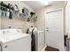 Well-organized laundry room equipped with modern washer and dryer and overhead storage at 70 Locust Pass Run, Ocala, FL 34472
