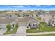Aerial view of home with solar panels, lush landscaping, a two-car garage, and a manicured lawn at 733 Citrus Reserve Blvd, Davenport, FL 33837