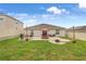 Spacious backyard featuring a paved patio with grill, dining set, and green lawn at 733 Citrus Reserve Blvd, Davenport, FL 33837