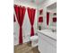 Bathroom featuring a white vanity, neutral colors, a toilet, and red-themed decorations at 733 Citrus Reserve Blvd, Davenport, FL 33837