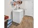 Bright laundry room features a washer and dryer and storage shelves for supplies and linens at 733 Citrus Reserve Blvd, Davenport, FL 33837