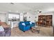 Bright living room with blue sofa, wood-look tile, and an open layout to the kitchen and dining area at 733 Citrus Reserve Blvd, Davenport, FL 33837