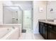 Bathroom with a soaking tub, glass-enclosed shower, and vanity at 8800 Corcovado Dr, Kissimmee, FL 34747