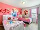 Delightful bedroom with two twin beds, Disney princess wall art, and bright natural light from the window at 8800 Corcovado Dr, Kissimmee, FL 34747