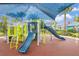 Colorful playground featuring slides, climbing structures, and a shaded seating area at 8800 Corcovado Dr, Kissimmee, FL 34747