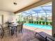 Screened-in pool with table, chairs and sun loungers at 8800 Corcovado Dr, Kissimmee, FL 34747