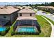 Aerial view of a screened-in pool and backyard of a home with lush green lawn and landscaping at 8800 Corcovado Dr, Kissimmee, FL 34747