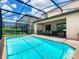 A view of a screened-in backyard pool with a patio and outdoor seating at 8800 Corcovado Dr, Kissimmee, FL 34747