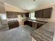 Spacious kitchen with dark wood cabinets, granite countertops, and ample natural light pouring in, ready for customization at 891 Cr 482C, Lake Panasoffkee, FL 33538