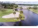 Aerial view of a lake and golf course with a sand trap and lush greenery in a waterfront community at 9335 San Jose Blvd, Howey In The Hills, FL 34737