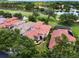 Beautiful home in a golf course community, featuring a red tile roof, mature landscaping, and screened in pool at 9335 San Jose Blvd, Howey In The Hills, FL 34737