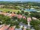 Aerial view of a beautiful golf course community with a lake, lush landscaping and lovely red tile roof homes at 9335 San Jose Blvd, Howey In The Hills, FL 34737