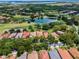 Aerial view of a beautiful community with lush landscaping, a lake, golf course and luxurious red tile roof homes at 9335 San Jose Blvd, Howey In The Hills, FL 34737