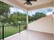 Charming balcony with tile flooring and wrought iron railings, overlooking mature trees at 9335 San Jose Blvd, Howey In The Hills, FL 34737