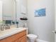Powder room with an oak vanity and a wall with decorative artwork at 9335 San Jose Blvd, Howey In The Hills, FL 34737