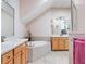 Bright bathroom with a soaking tub, double sinks, and vanity lighting at 9335 San Jose Blvd, Howey In The Hills, FL 34737