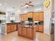 Well-lit kitchen boasting granite countertops, wood cabinets, stainless fridge and a breakfast bar at 9335 San Jose Blvd, Howey In The Hills, FL 34737
