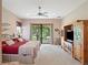Large bedroom with a balcony, a ceiling fan, and neutral-toned walls at 9335 San Jose Blvd, Howey In The Hills, FL 34737