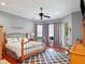 Bedroom with a metal frame bed, a ceiling fan, and wood floors covered by a large rug at 9335 San Jose Blvd, Howey In The Hills, FL 34737