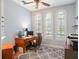 Bright office with three arched windows, plantation shutters, ceiling fan, hardwood floors, and traditional wood desk at 9335 San Jose Blvd, Howey In The Hills, FL 34737