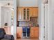 Beautiful wet bar featuring wood cabinets, granite counters, a wine fridge and mosaic tile backsplash in the entertainment area at 9335 San Jose Blvd, Howey In The Hills, FL 34737