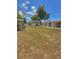 Vast backyard with a privacy fence, a storage shed and a lattice patio cover, offering a blend of privacy and outdoor space at 100 W Idlewild Ave, Eustis, FL 32726