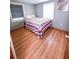 Comfortable bedroom with a quilt-covered bed, hardwood floors, and natural light from two windows at 100 W Idlewild Ave, Eustis, FL 32726