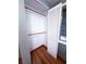 Bright closet featuring hardwood floors, two wooden rods for storage, and a bi-fold door with a window at 100 W Idlewild Ave, Eustis, FL 32726