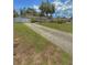 View of home with long driveway, enhanced by mature trees and flowering bushes at 100 W Idlewild Ave, Eustis, FL 32726