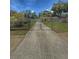 Long driveway leading to a charming home surrounded by lush greenery and a secure fenced yard at 100 W Idlewild Ave, Eustis, FL 32726