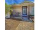 Inviting porch with blue door and paved walkway, complemented by mature landscaping at 100 W Idlewild Ave, Eustis, FL 32726