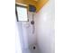 Shower with a showerhead, white tiled walls, and a window for natural light at 100 W Idlewild Ave, Eustis, FL 32726