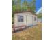 Rustic storage shed with a traditional design, complemented by a bench, offering a functional space for storage and projects at 100 W Idlewild Ave, Eustis, FL 32726