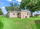 Exterior home view with a spacious backyard and mature trees at 1005 Richard Dr, The Villages, FL 32159