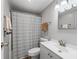 Well-lit bathroom with a shower and tub featuring a modern, striped shower curtain at 1005 Richard Dr, The Villages, FL 32159