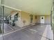 Covered carport area with painted concrete floor and exterior storage closet, providing ample covered parking at 1005 Richard Dr, The Villages, FL 32159